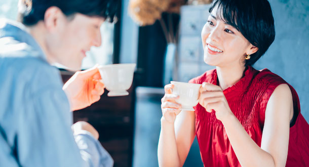 ティーカップを持って会話する男女
